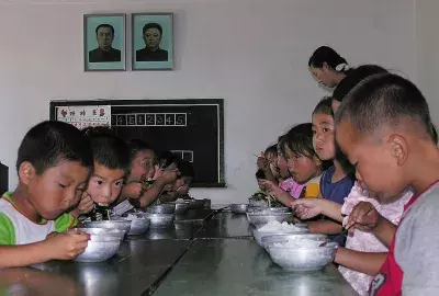 North Korean children eat lunch at a government run kindergarten (Photo by Gerald Bourke/World Food Programme via Getty Images)