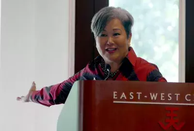 East-West President Suzy Vares-Lum smiles behind a podium