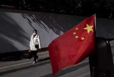 esidents wear masks while walking in street as the national flag waves on November 30, 2021 in Wuhan, China. Life for many of the residents in Wuhan is returning to normal a year and a half after the city imposed strict lockdowns to reduce the spread of COVID-19. (Photo by Getty Images)
