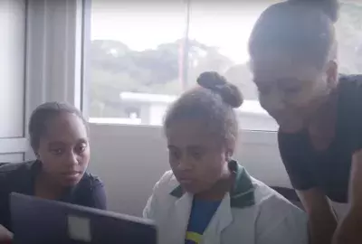 Three girls taking part in the Smart Sistahs program looking at a computer