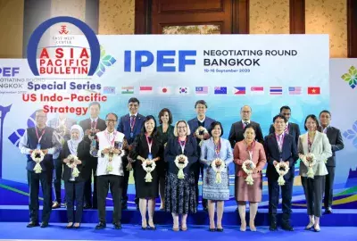 APB Arch indo-pacific special series logo overlaying  a photo of officials from IPEF signatory countries standing on a dais in front of a blue backdrop with a stylized title for the IPEF Bangkok negotiation at its head