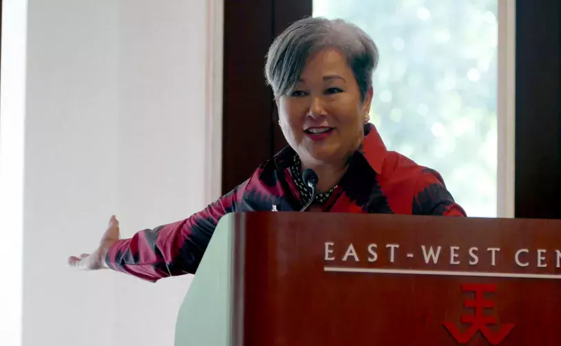 East-West President Suzy Vares-Lum smiles behind a podium