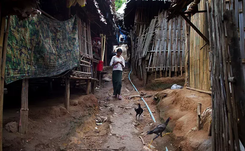 A woman walks along a muddy path inside the Mae La refugee camp June 7, 2012 in Tak province, Thailand. 