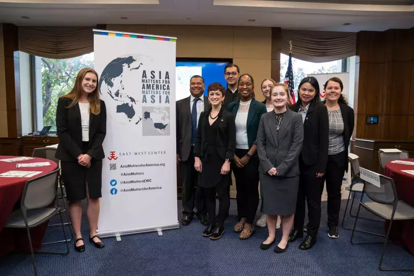 EWC in Washington team stands beside a banner reading "Asia Matters for America"